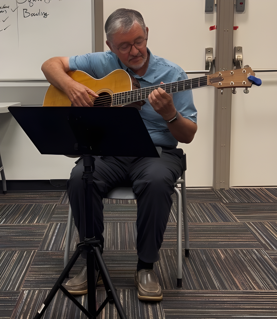 A fellow member from the community playing the guitar.